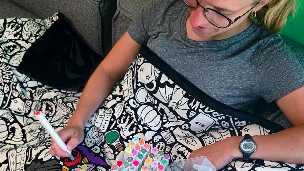 Michelle Mildred coloring a Coloring Your Own blanket with markers