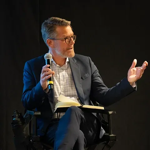 A speaker with a microphone during a seated session at IPx LA